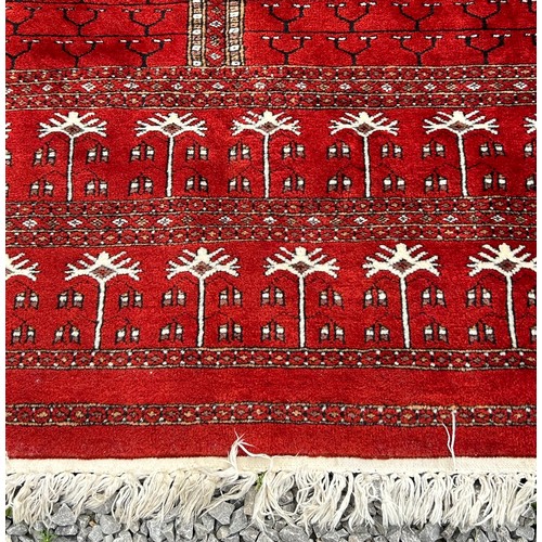 1221 - A large red Kashmir wool carpet. Approx. 179 x 280cm.