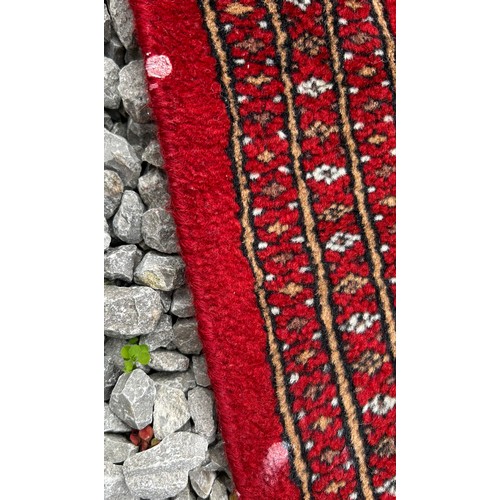 1221 - A large red Kashmir wool carpet. Approx. 179 x 280cm.