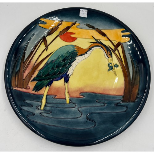 213 - A Moorcroft charger depicting a heron amongst bullrushes. 35cm d.