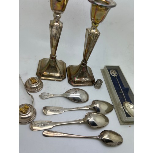 765 - Hallmarked silver to include a pair of candlesticks, Birmingham 1919, with weighted bases,  spoons, ... 