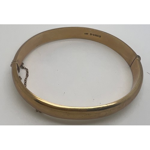 647 - Nine carat gold hinged bangle with etched decoration to one side. Weight 12.2gm.