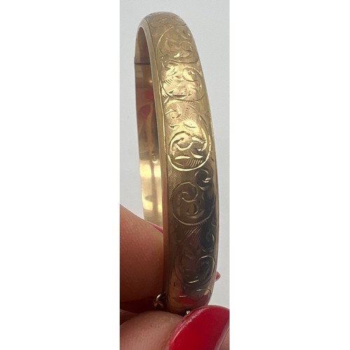 647 - Nine carat gold hinged bangle with etched decoration to one side. Weight 12.2gm.