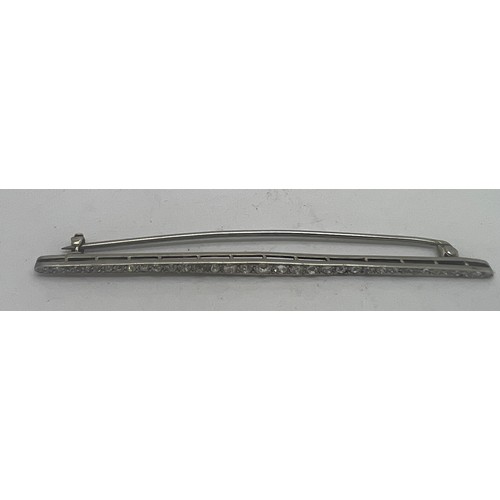 660 - A diamond bar brooch set in white metal which tests as platinum. Weight 4.5gm. 8cm l.