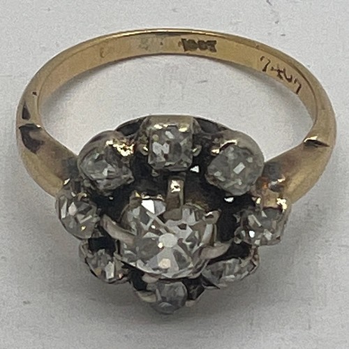 661 - A 19thC diamond set cluster ring in 18 carat yellow gold, comprising of a central four claw and grai... 