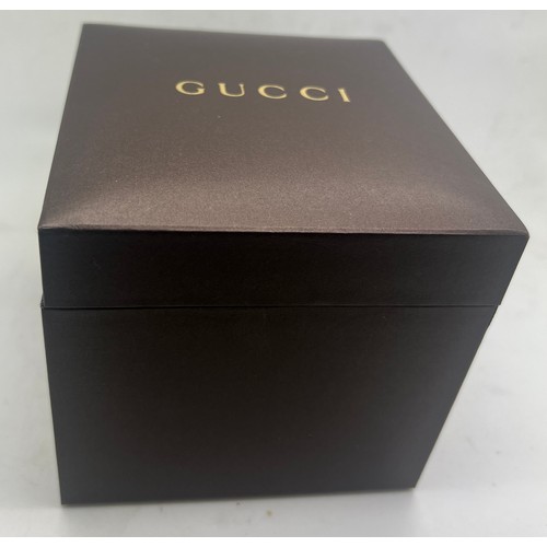 711 - A ladies Gucci wristwatch set with two diamonds in original presentation box.