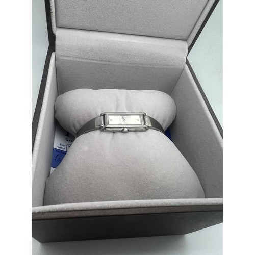 711 - A ladies Gucci wristwatch set with two diamonds in original presentation box.