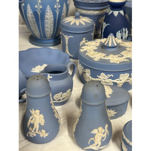 182 - A quantity of Wedgwood Jasperware, blue and dark blue to include a tall jug with lily of the valley ... 