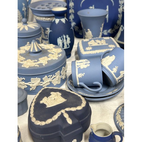 182 - A quantity of Wedgwood Jasperware, blue and dark blue to include a tall jug with lily of the valley ... 