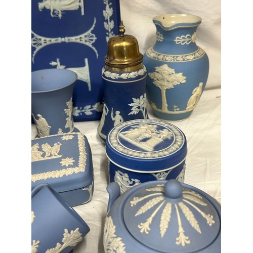 182 - A quantity of Wedgwood Jasperware, blue and dark blue to include a tall jug with lily of the valley ... 