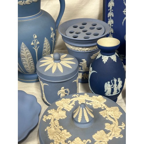 182 - A quantity of Wedgwood Jasperware, blue and dark blue to include a tall jug with lily of the valley ... 