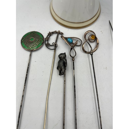 616 - A collection of hatpins and two hatpin holders, one silver and one Noritake to include silver teddy,... 