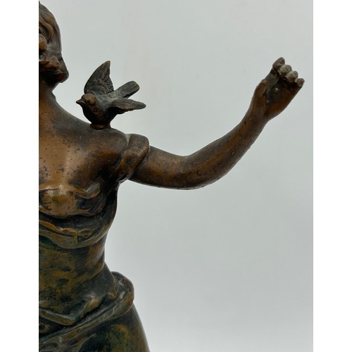 1303 - A late 19thC Spelter Figurine Charmeuse by R. Richard depicting a woman with two doves. 44cm h.