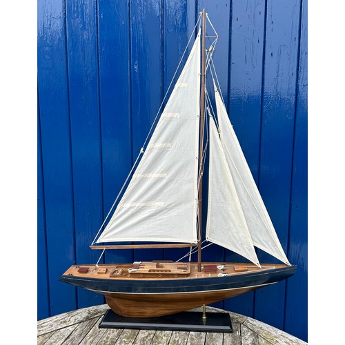 1305 - A single masted pond yacht on a permanent stand. Total height 99cm h x 77cm w.