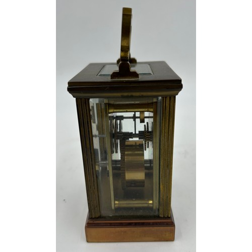 1002 - A Brass Mantle Carriage Clock with roman numeral dial with gilt case and bevelled glass windows surr... 