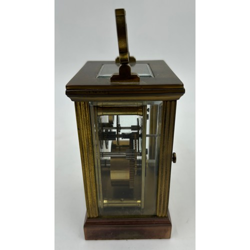 1002 - A Brass Mantle Carriage Clock with roman numeral dial with gilt case and bevelled glass windows surr... 