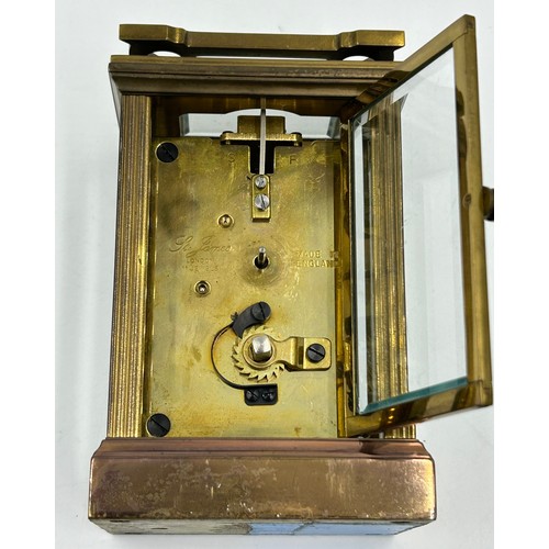 1002 - A Brass Mantle Carriage Clock with roman numeral dial with gilt case and bevelled glass windows surr... 