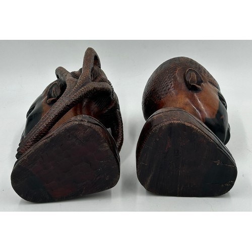 925 - A pair of mid 20thC Nigerian carved hard wood heads, one male one female. Both 26cm.