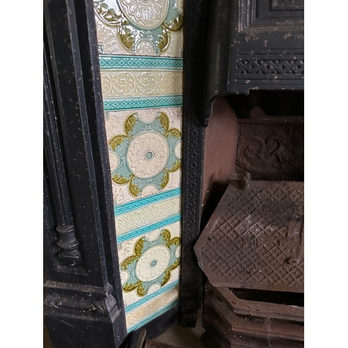 39 - A Victorian cast iron fireplace with tiled insert together with trivets, fender, early 20thC racehor... 