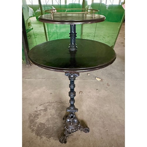 38 - A vintage pub table with two tier wooden top and brass gallery  with heavy cast iron base with two f... 