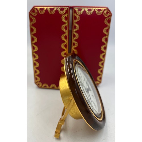 1001 - A Cartier Paris travel alarm clock in original red leather presentation case. 9cm x 7cm.