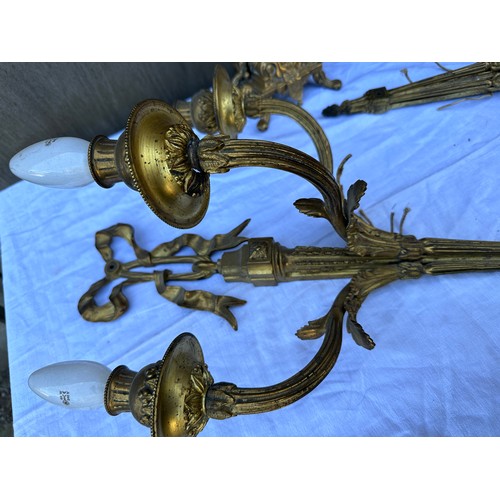 1015 - Two decorative three branch wall lights 54cm h together with two brass candelabras 42.5cm h. One loo... 