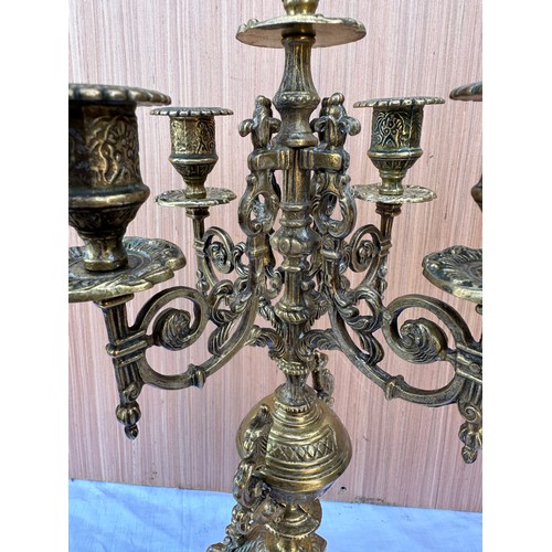 1015 - Two decorative three branch wall lights 54cm h together with two brass candelabras 42.5cm h. One loo... 