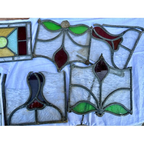 33 - A quantity of stained glass panels, to include a set of four matching with diamond shapes to centre,... 