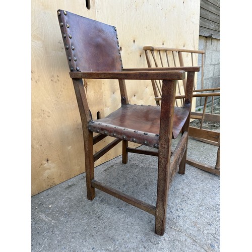 57 - Two chairs to include Ercol style mid century rocking chair and an oak leather seated carver chair.