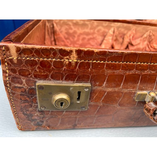 1317 - A vintage crocodile leather suitcase initialed R.W with brass fittings. Suitcase measures 56cm wide ... 