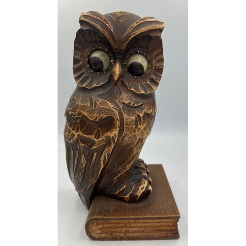 1006 - A German carved owl mantel clock, the owl seated on a book, having movement in his eyes. Stamped Ger... 