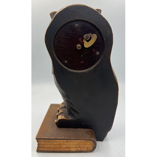 1006 - A German carved owl mantel clock, the owl seated on a book, having movement in his eyes. Stamped Ger... 