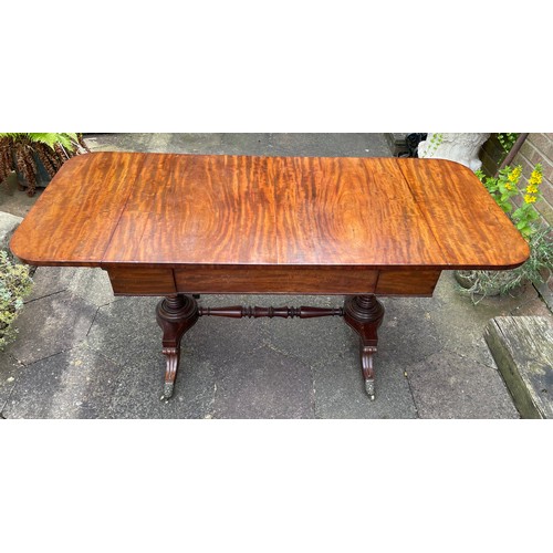 43 - A William IV figured mahogany sofa table on turned stretcher base terminating in reeded sabre legs w... 