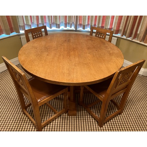 140 - A circular oak dining table with adzed top 128cm d x 73.5cm h together with four lattice backed dini... 