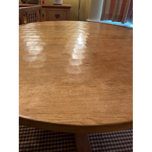 140 - A circular oak dining table with adzed top 128cm d x 73.5cm h together with four lattice backed dini... 