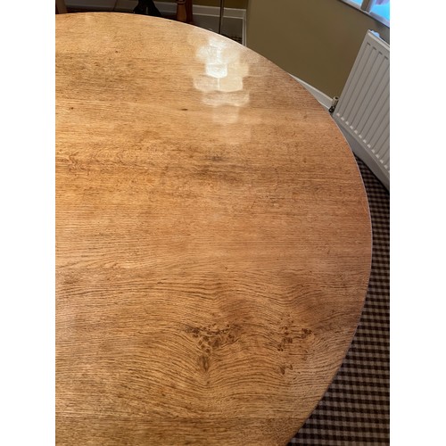 140 - A circular oak dining table with adzed top 128cm d x 73.5cm h together with four lattice backed dini... 