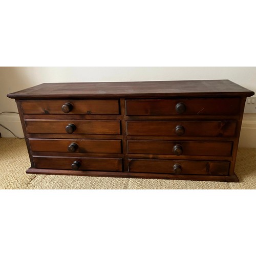 47 - A stained pine chest of eight drawers. Approximately 35cm h x 28cm d x 94cm w.