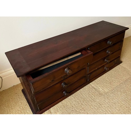 47 - A stained pine chest of eight drawers. Approximately 35cm h x 28cm d x 94cm w.