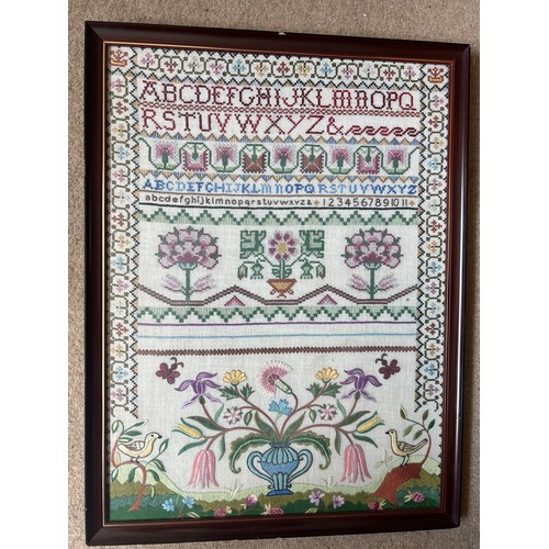 835 - A 20thC silk cross stitch and crewel work sampler. 54cm x 40cm.