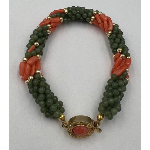 600 - A coral and jade bead twisted bracelet with yellow metal clasp. 18cm l.