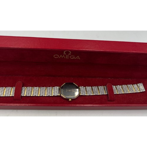 724 - A ladies’ Omega De Ville wristwatch with black face and metal strap in original case.