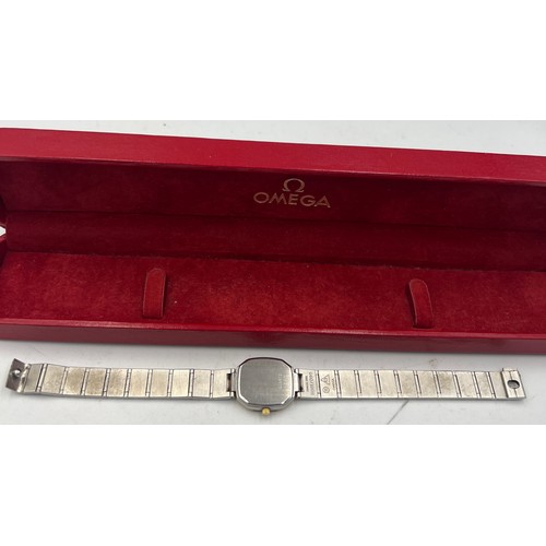 724 - A ladies’ Omega De Ville wristwatch with black face and metal strap in original case.