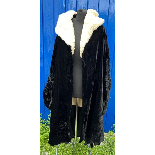 836 - A 1920’s black fur evening coat with white fur collar, cream silk lining and rouged sleeves.