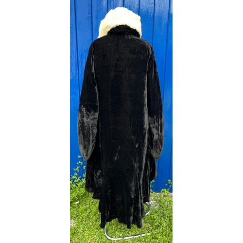 836 - A 1920’s black fur evening coat with white fur collar, cream silk lining and rouged sleeves.