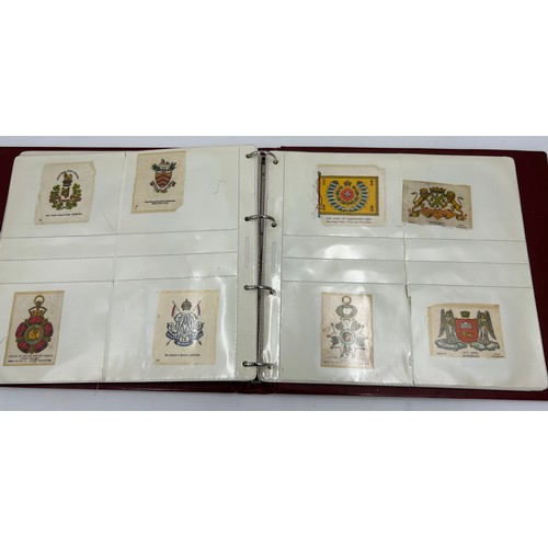 919 - An album containing 132 cigarette silks to include 29 x Kensitas, plus BDV etc. - Heraldic, Colonial... 