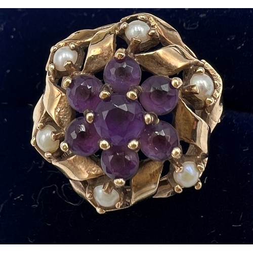 588 - A nine carat gold ring set with seed pearls and garnets. Size M. Weight 4.2gm.