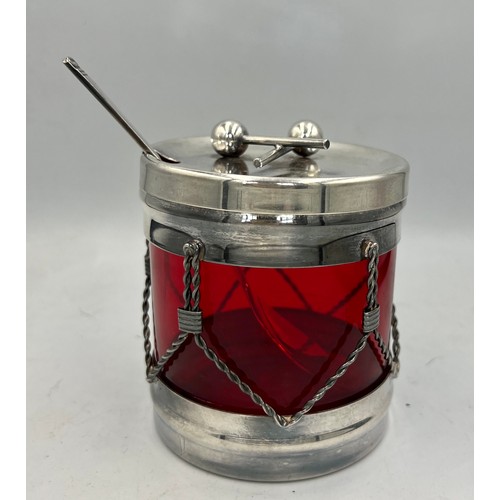 24 - A Viners International ruby glass lined preserve jar in the form of a drum with silver plated frame ... 