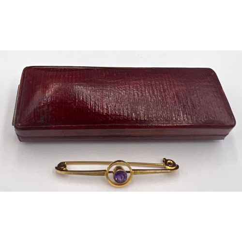 84 - An 9 carat gold Art Deco target brooch set with a circular amethyst in a red leather silk lined pres... 