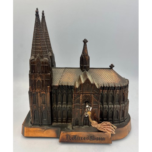 66 - A copper music box in the form of Cologne Cathedral, the roof lifting to reveal a red satin lined in... 