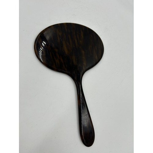 252 - An early 20th century faux tortoiseshell hand mirror. 33cm h x 19.5cm w.