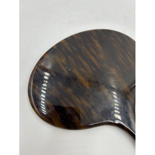 252 - An early 20th century faux tortoiseshell hand mirror. 33cm h x 19.5cm w.